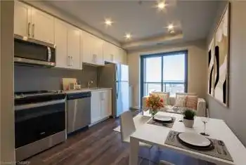 Kitchen featuring appliances with stainless steel finishes, backsplash, sink, dark hardwood / wood-style floors, and white cabinetry